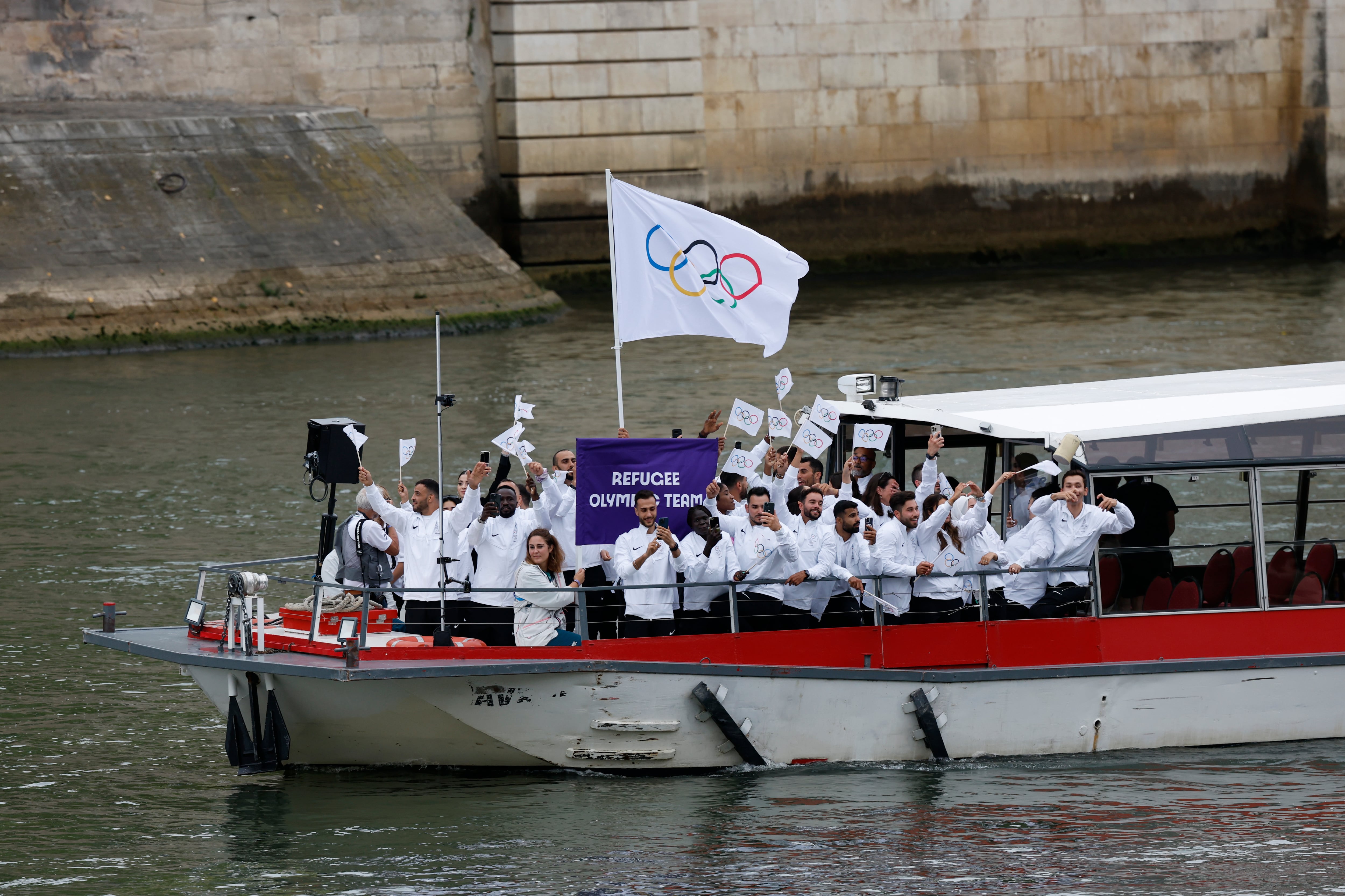 La selección de refugiados bajo la bandera de las olimpiadas desfilan por el río Sena, durante la ceremonia de inauguración de los Juegos Olímpicos de París 2024, este viernes en la capital francesa. EFE/Julio Muñoz