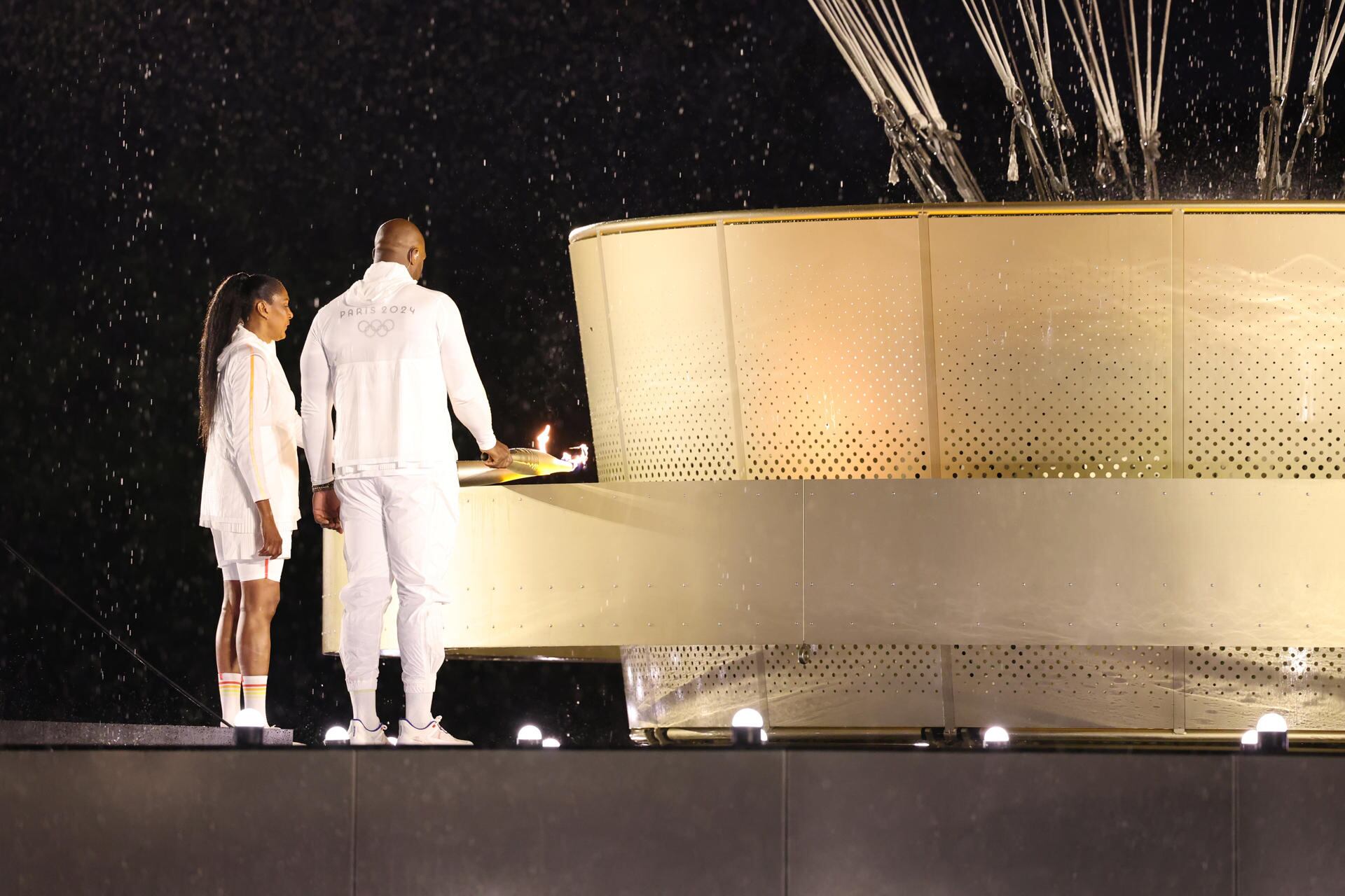 Los atletas galos Marie-Jose Perec (i) y Teddy Riner (d) encienden el pebetero durante la ceremonia de inauguración de los Juegos Olímpicos de París 2024. EFE