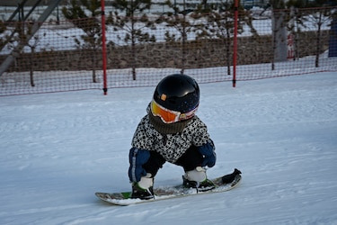 Bebé de 11 meses con su tabla de snowboard, estrella de internet en China