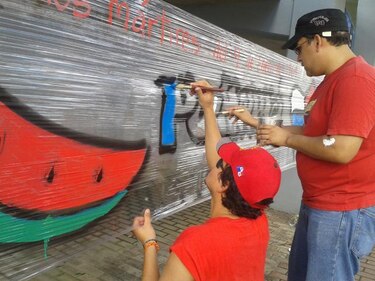 Ante la mirada de policías, El Kolectivo recrea mural en honor a mártires