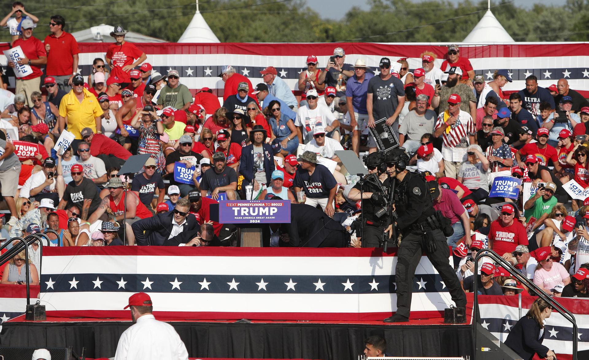 El expresidente estadounidense Donald Trump es sacado del escenario por el Servicio Secreto. EFE