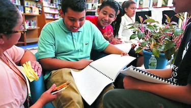 Niños escriben historias en libro