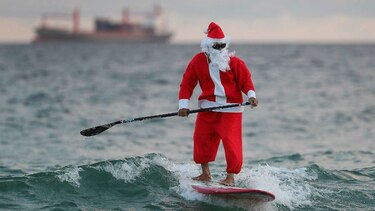 Personas disfrazadas de Santa Claus surfean en Florida