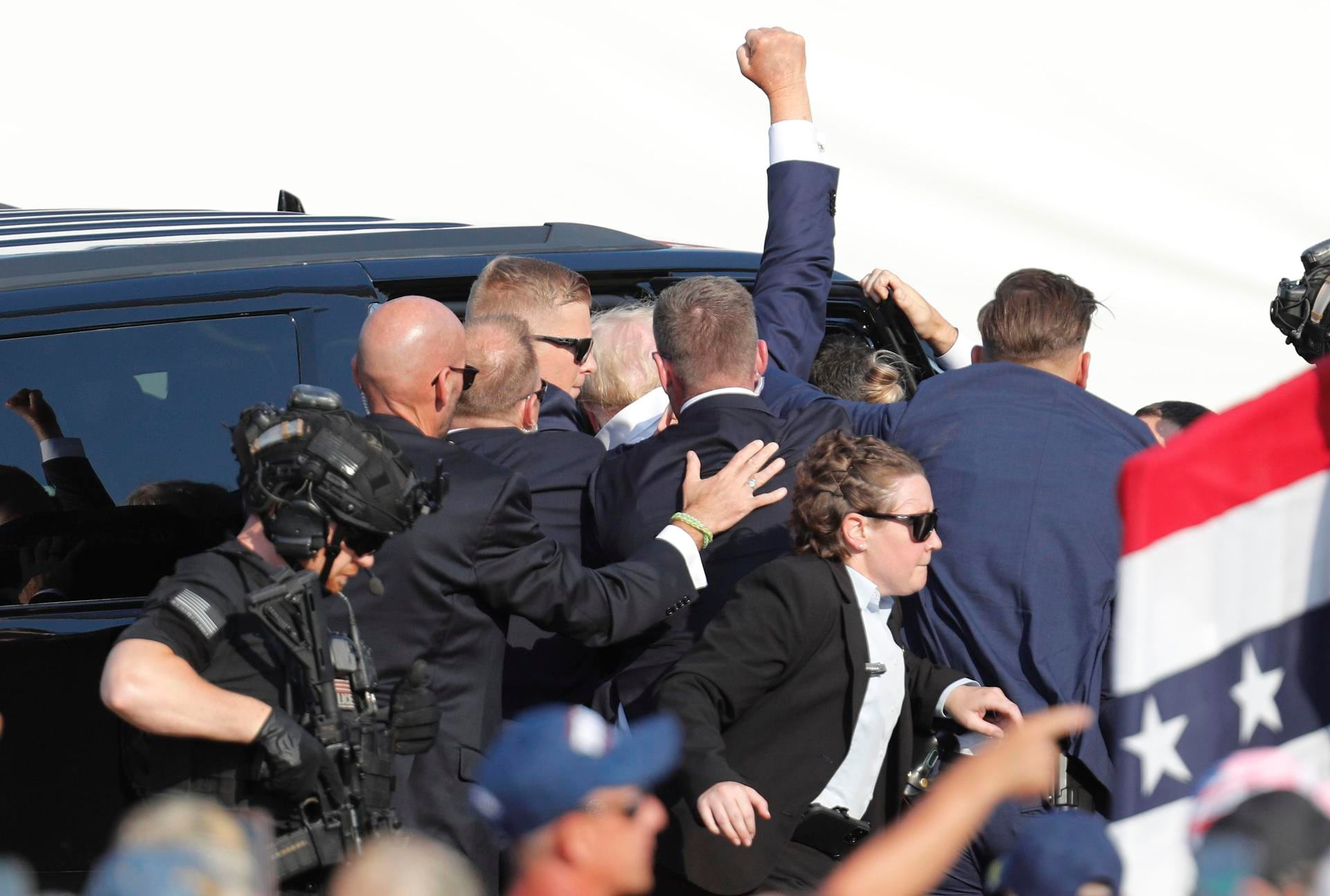 El expresidente estadounidense Donald Trump levanta el puño mientras el Servicio Secreto lo saca del escenario. EFE