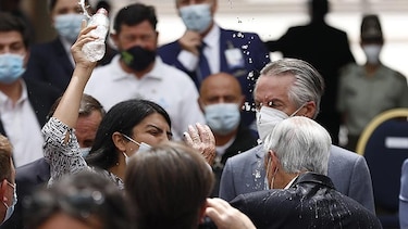 Una mujer lanza agua al presidente chileno Piñera en un acto en La Moneda