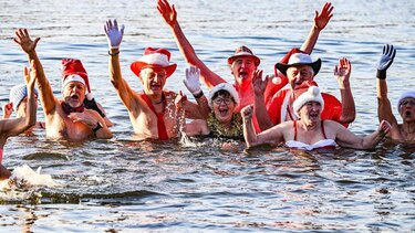 Docenas de personas siguen tradición navideña y se bañan en el lago berlinés Orankesee