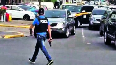 Policía enseña su arma en la calle